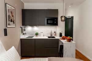 科隆NUVA Apartments的厨房配有黑色橱柜和白色台面