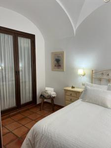 Herrera del DuqueCasa Rural Mijarra ****的一间卧室配有一张床、一张桌子和一个窗户。
