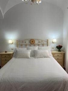 Herrera del DuqueCasa Rural Mijarra ****的一间卧室配有白色床和2个床头柜
