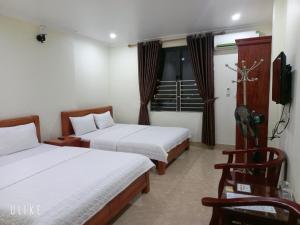 下龙湾Guesthouse Anh Khang的酒店客房设有两张床和电视。