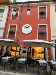 格拉多Ca’ Bruno Masaneta的大楼前的餐厅,配有桌子和遮阳伞
