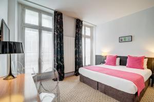 巴黎柯马丁歌剧院阿斯托利亚酒店的卧室配有一张带粉红色枕头的大床
