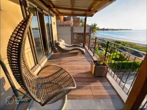 塔马兰Beachfront Villa by M&H的阳台配有椅子,背靠大海