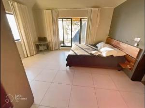 塔马兰Beachfront Villa by M&H的卧室配有1张床,铺有瓷砖地板。