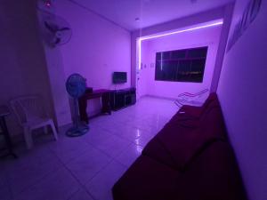 伊基托斯Moicca Youth Hostel的紫色的客房配有沙发和风扇