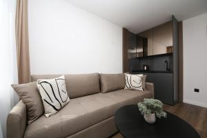 萨拉热窝Nest Apartments Sarajevo的客厅配有沙发和桌子