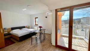 卢布尔雅那Apartments Katrca Bežigrad的一间卧室配有一张床铺和一张桌子,并设有一个阳台