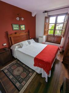 桑提亚纳德玛Posada Revolgo的一间卧室配有一张带红色毯子的大床