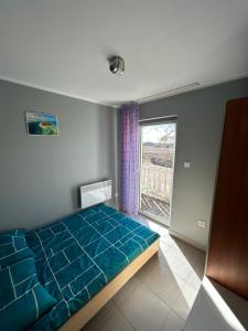 ŁuszczewoHacjenda的一间卧室设有蓝色的床和窗户。