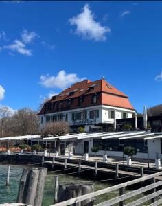 施坦贝尔格湖畔贝格Strandhotel Berg的水边有红色屋顶的建筑