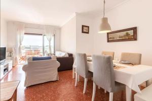 滨海比拉萨尔Apartment Muralla的客厅设有餐桌和椅子
