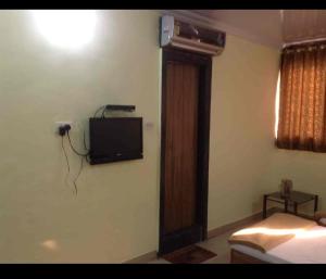 浦那Hotel Rachana Residency的卧室设有壁挂式电视和床。