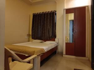 浦那Hotel Rachana Residency的一间小卧室,配有床和窗户