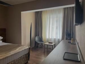 博罗沃耶Hotel Gloria Deluxe的卧室配有床、椅子和窗户。