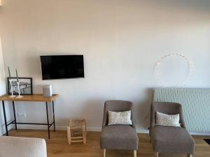 勒图凯-巴黎普拉日Le Touquet : Appt 4 pers face mer的客厅配有两把椅子、一张桌子和一台电视
