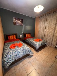 卡兰巴卡Teo's House 2的一间卧室配有两张床,备有橙色浴袍