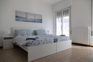贝拉吉奥Casa Margherita Bellagio的白色卧室配有一张带蓝色床单的大床