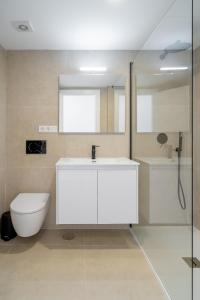 内尔哈Solymar Sun & Beach Deluxe Apartments的浴室配有白色水槽和卫生间。