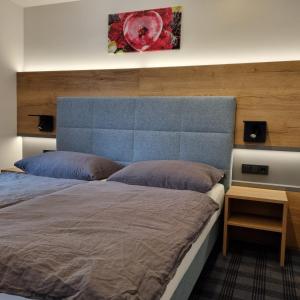斯拉德明Das Geringer的一间卧室配有一张大床和蓝色床头板