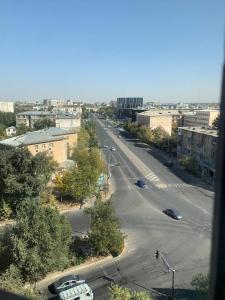 奇姆肯特КВАРТИРА с видом на площадь的享有城市街道的景色,路边有汽车