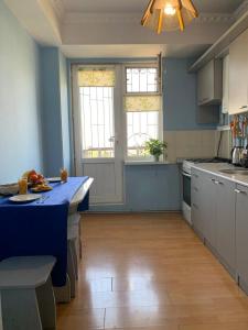 奇姆肯特КВАРТИРА с видом на площадь的厨房设有蓝色的墙壁和蓝色的台面