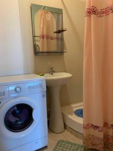 奇姆肯特КВАРТИРА с видом на площадь的一间带洗衣机和水槽的浴室