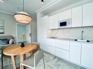 奇皮奥纳鲁兹码头公寓酒店的厨房配有白色橱柜和木桌