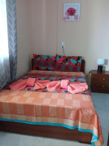 卡兰巴卡Teo's House 1的一间卧室配有一张带粉色和橙色床单的床