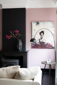 丽兹Suite 137, luxe verblijf midden in de bollenstreek的客厅配有沙发和墙上的照片