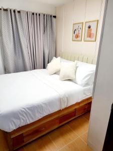 卡加盐德奥罗Steff's Condo 2622 at One Oasis的一张带白色床单和枕头的床