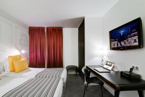 巴黎阿斯托利亚乔伊斯酒店的配有一张床和一张书桌的酒店客房