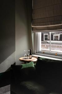 伦敦亨利埃塔酒店的一间配有沙发和一张桌子及窗户的房间