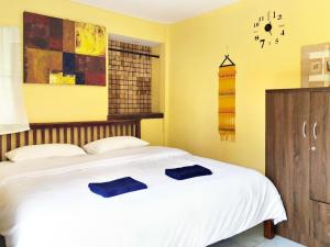 Baanphakrimlay Blue Beach Resort的一间卧室配有一张带两个蓝色枕头的床