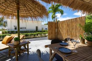 高兰Manao Pool Villa 1 - 5 Mins Walk To The Beach的一个带桌子和草伞的庭院
