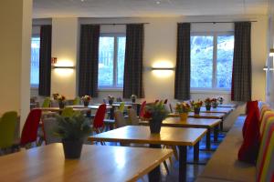 采德豪斯Sporthotel Zederhaus的餐厅设有木桌、椅子和窗户。
