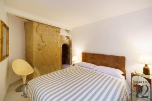 恩纳Habitat 72的一间卧室设有一张床和石墙