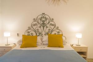 莱乌卡Villa Romasi的一间卧室配有一张带两个黄色枕头的床
