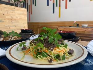 河江Rainbow House Ha Giang的盘子上摆着餐桌的食物