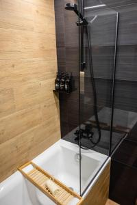 VratsaDa Vinci Apartment的带淋浴和白色浴缸的浴室
