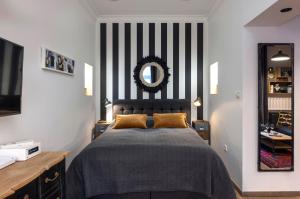 萨格勒布三七公寓的一间卧室配有一张带黑白条纹墙的床