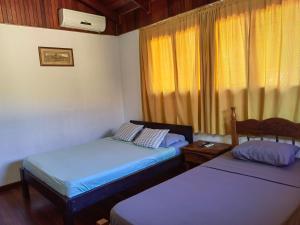 普拉亚埃尔莫萨Condominio Villa Hermosa的客房设有两张床和窗户。