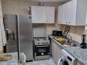 BedmarCasa rural El Parral的厨房配有冰箱、炉灶和水槽