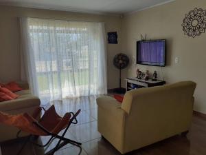 伊塔波阿Férias Perfeitas, Praia e Piscina的带沙发和平面电视的客厅