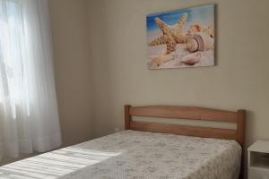 伊塔波阿Férias Perfeitas, Praia e Piscina的卧室配有一张床,墙上挂着一幅画