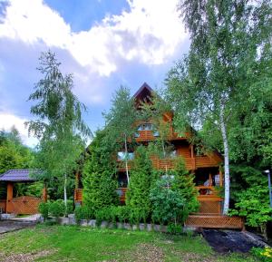 米戈韦Gostynniy Dvir Коттеджи的周围种有树木和植物的小木屋
