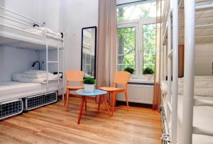 华沙Warsaw Hostel Centrum Private Rooms & Dorms的客房设有两张双层床和一张桌子及椅子。