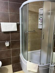 新帕扎尔艾蒂尔公寓的浴室里设有玻璃门淋浴