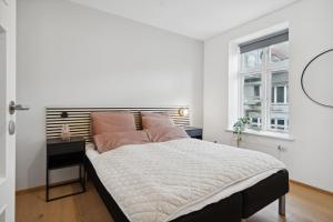 奥尔堡Central 3-bedroom apartment with a big terrace and fitness room的白色的卧室设有一张大床和一个窗户