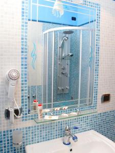 康加德马里尼伊尔帕沃食宿酒店的蓝色瓷砖浴室设有水槽和镜子