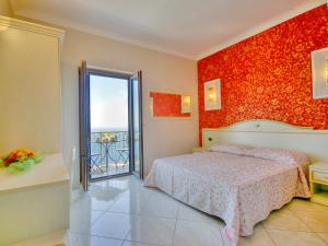 康加德马里尼伊尔帕沃食宿酒店的一间卧室设有一张床和红色的墙壁